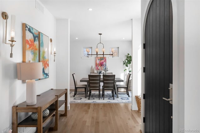 dining area featuring light hardwood / wood-style floors and an inviting chandelier