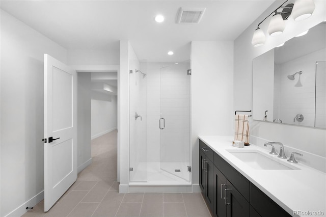 bathroom with tile patterned floors, vanity, and a shower with door