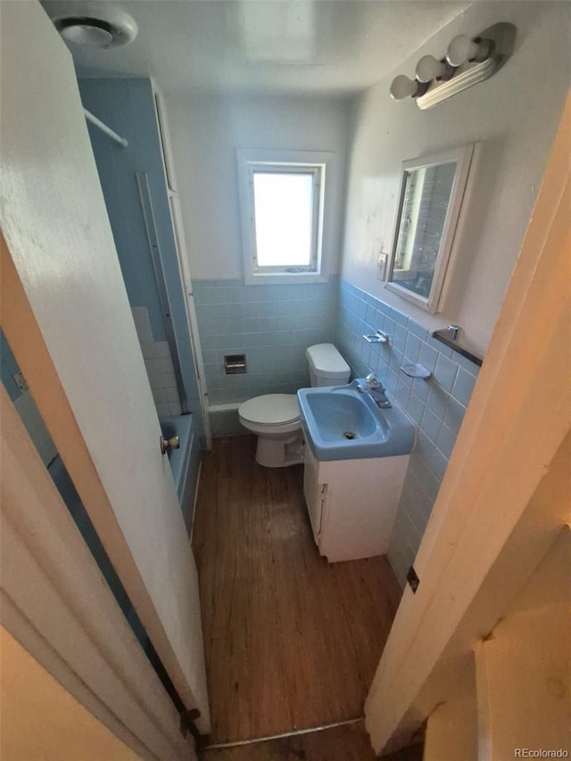 444 S Jersey St, Denver, CO 80224 - full bathroom with tile walls, toilet, wood finished floors, a wainscoted wall, and vanity
