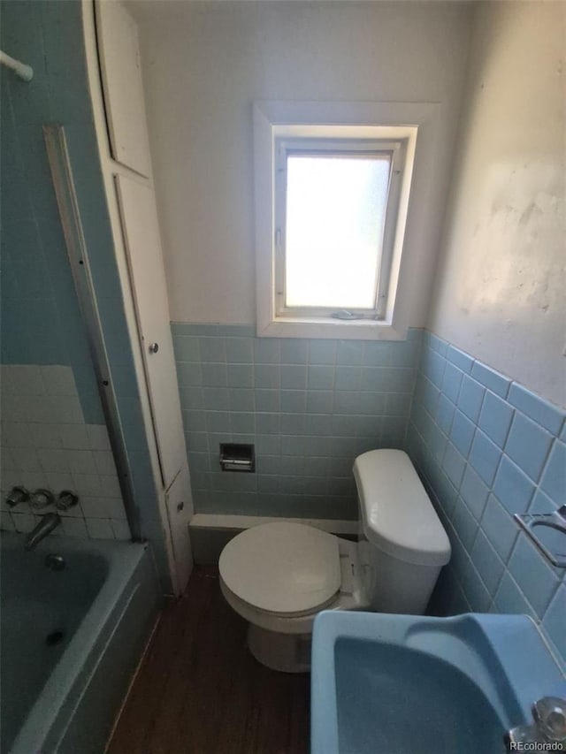 444 S Jersey St, Denver, CO 80224 - bathroom with tile walls, toilet, a bathtub, a wainscoted wall, and wood finished floors