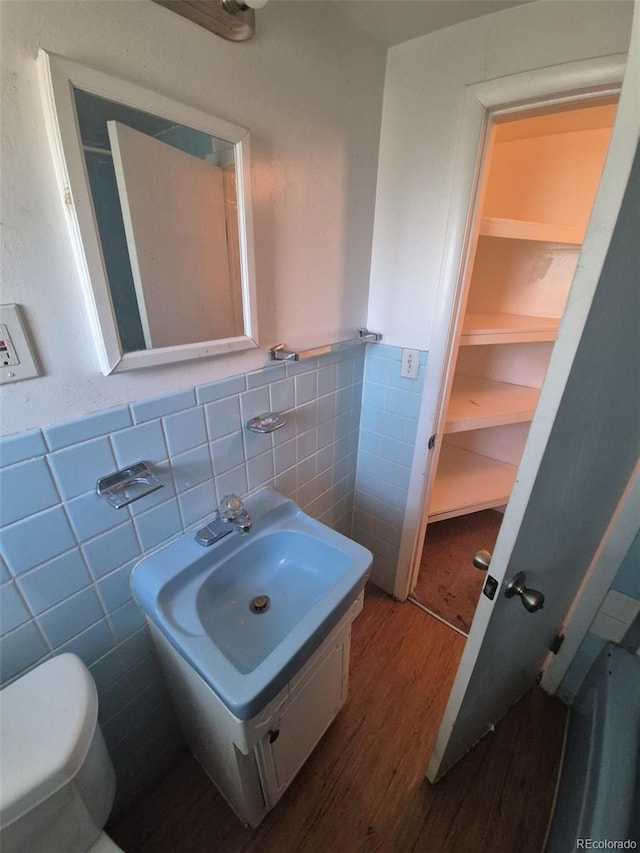 444 S Jersey St, Denver, CO 80224 - half bath featuring tile walls, wood finished floors, a wainscoted wall, toilet, and vanity