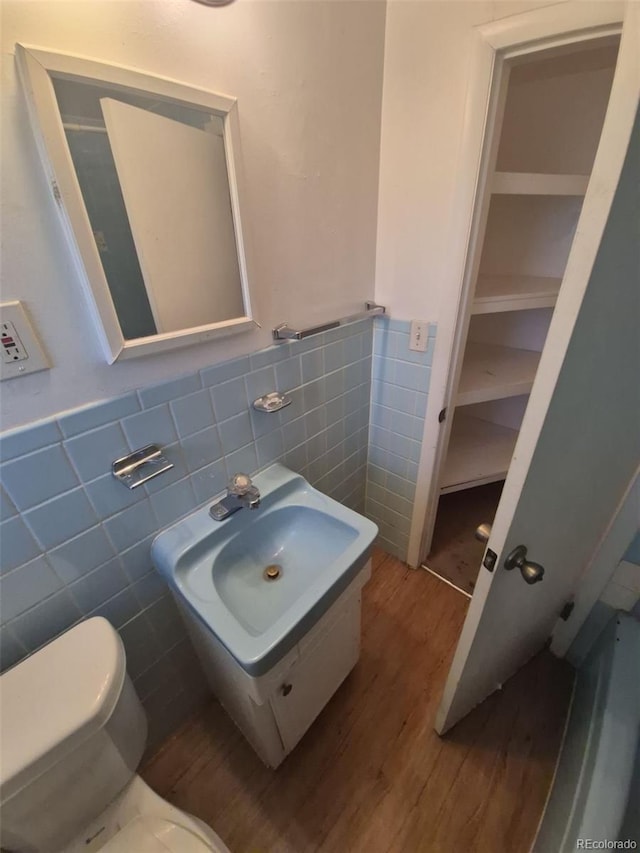 444 S Jersey St, Denver, CO 80224 - half bath with tile walls, wood finished floors, toilet, and a wainscoted wall