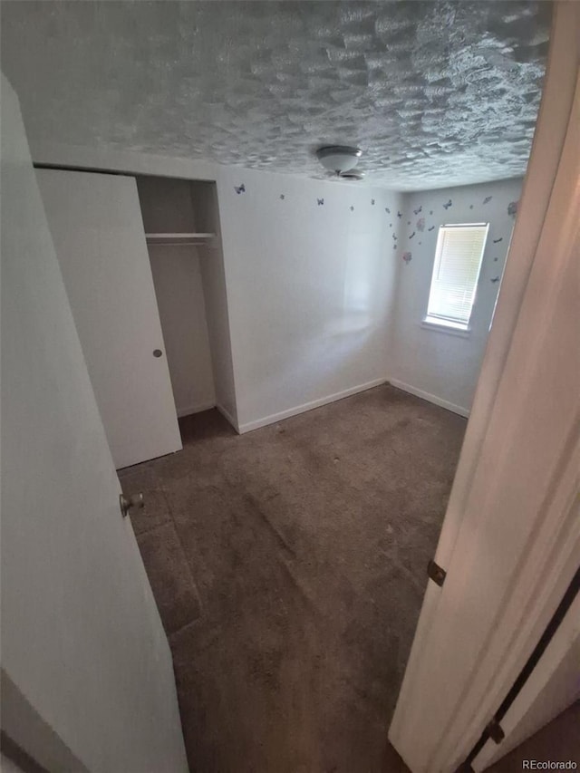 444 S Jersey St, Denver, CO 80224 - unfurnished bedroom with dark colored carpet, baseboards, a textured ceiling, and a closet