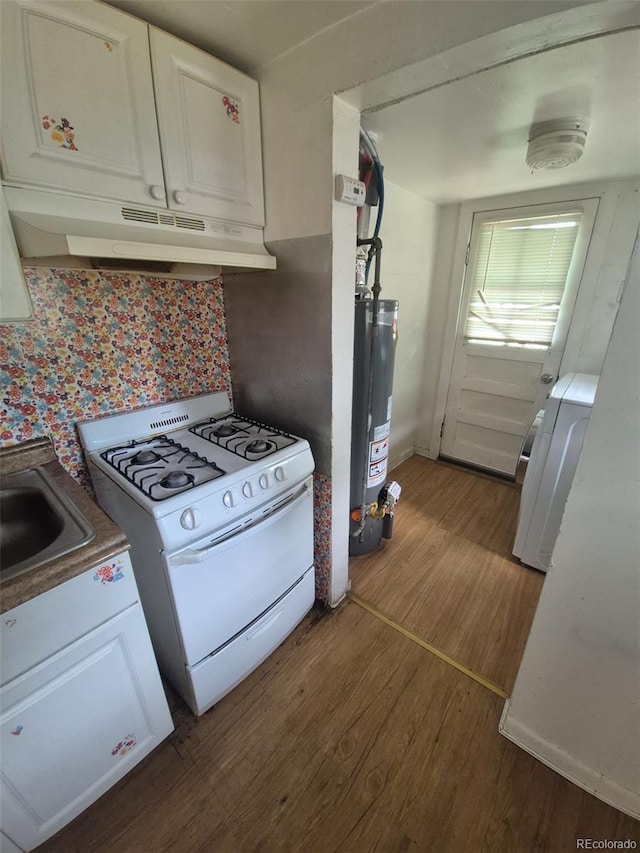 444 S Jersey St, Denver, CO 80224 - kitchen featuring white gas range oven, under cabinet range hood, gas water heater, washer / clothes dryer, and dark wood finished floors