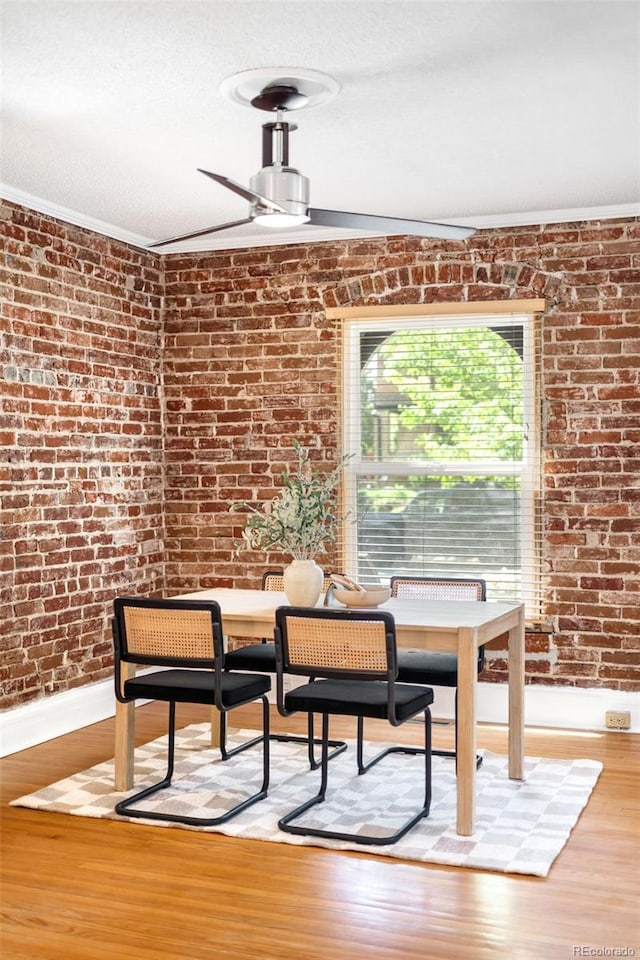 3375 W 37th Ave, Denver, CO 80211 - dining space featuring light wood-style flooring, brick wall, and baseboards