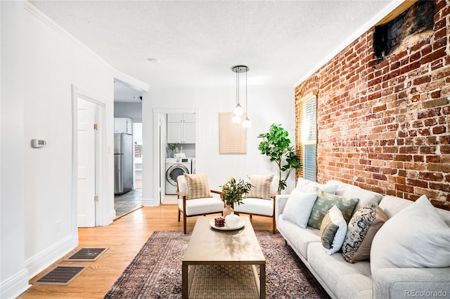 3375 W 37th Ave, Denver, CO 80211 - living room featuring brick wall, light wood-type flooring, baseboards, a textured ceiling, and crown molding