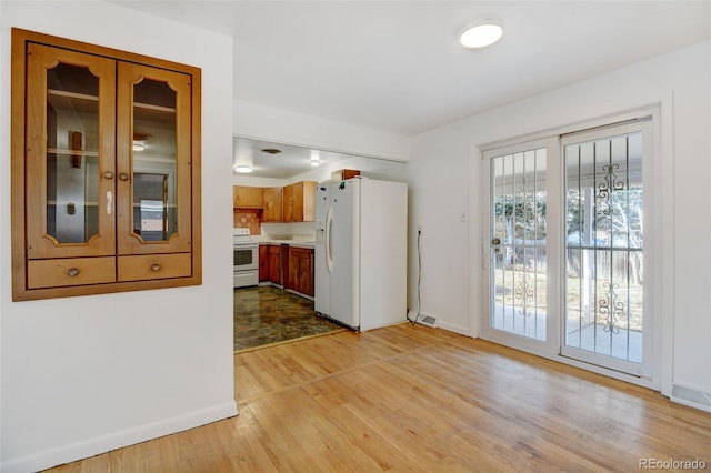 kitchen with light hardwood / wood-style flooring and white appliances