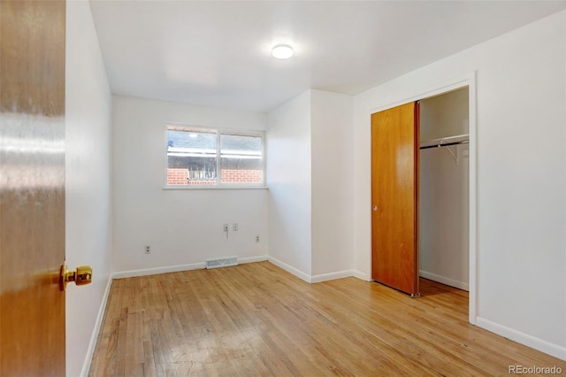 unfurnished bedroom featuring light hardwood / wood-style flooring and a closet