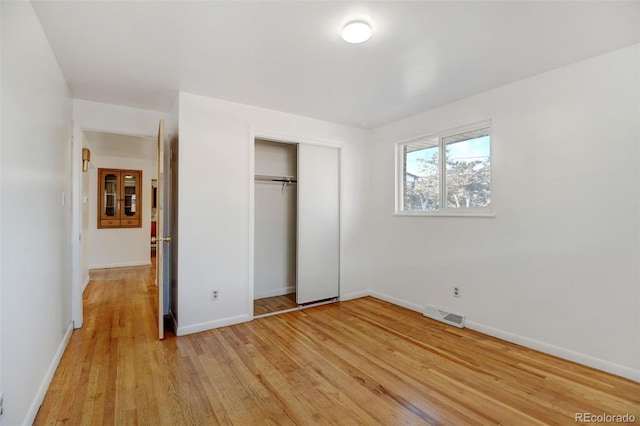 unfurnished bedroom with a closet and light hardwood / wood-style flooring