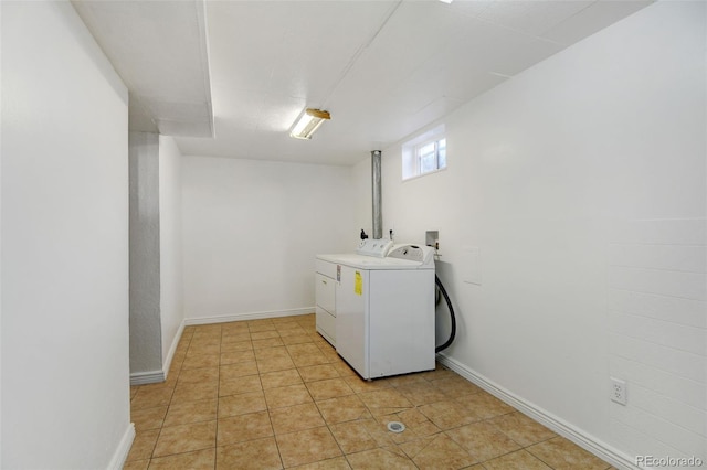 laundry room with independent washer and dryer and light tile patterned floors