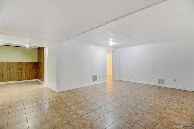 spare room with wooden walls and light tile patterned flooring