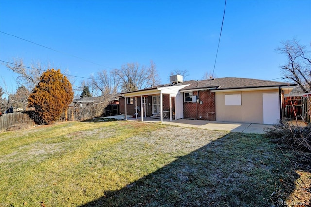 rear view of house with a patio area and a lawn