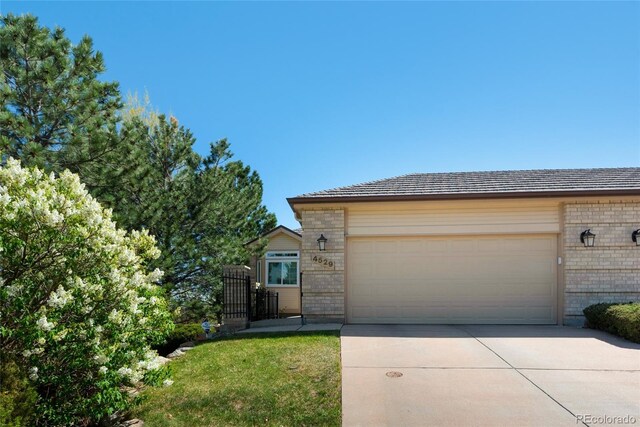 4529 Songglen Cir, Colorado Springs, CO 80906 - view of front of house featuring brick siding, concrete driveway, and an attached garage