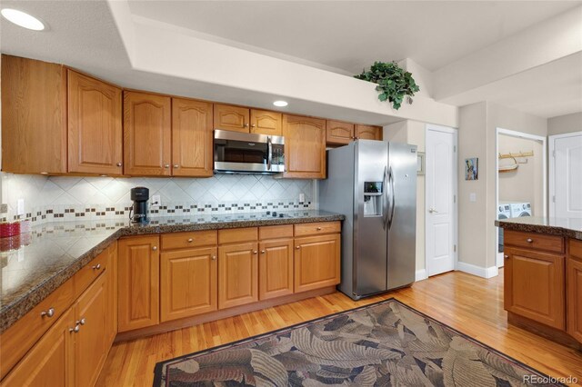 4529 Songglen Cir, Colorado Springs, CO 80906 - kitchen with appliances with stainless steel finishes, light wood-style floors, brown cabinetry, and tasteful backsplash