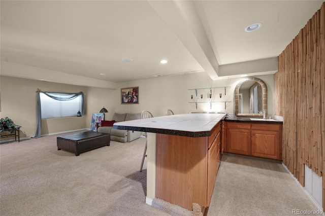 4529 Songglen Cir, Colorado Springs, CO 80906 - kitchen featuring light colored carpet, a kitchen breakfast bar, a peninsula, a sink, and recessed lighting