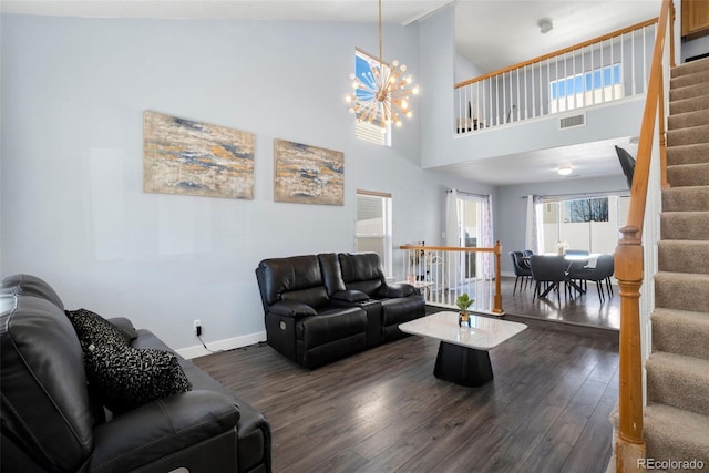 living room featuring an inviting chandelier, a towering ceiling, and dark hardwood / wood-style floors