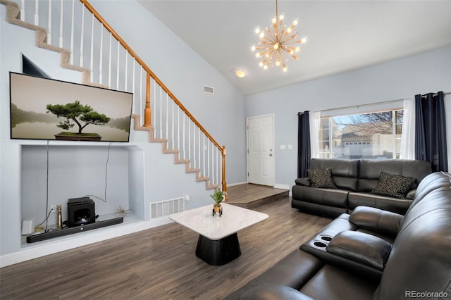 living room featuring dark hardwood / wood-style flooring, a towering ceiling, and a chandelier