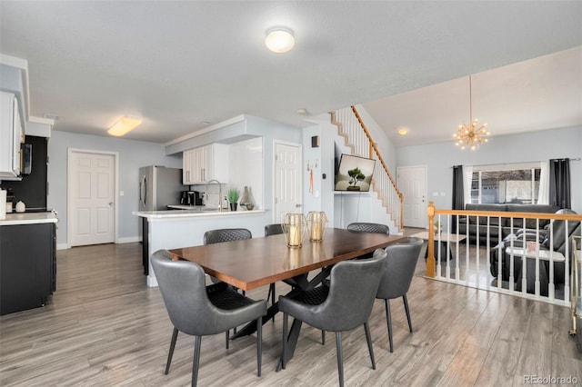 dining room with light hardwood / wood-style floors and a chandelier