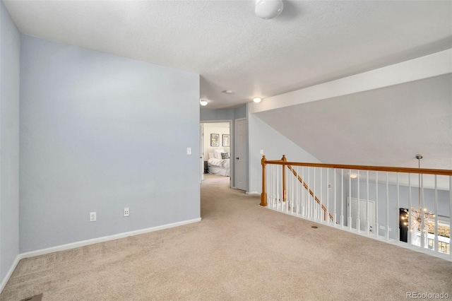 carpeted spare room featuring vaulted ceiling