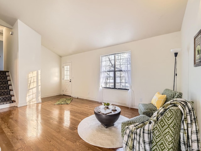 living room with light hardwood / wood-style flooring and vaulted ceiling