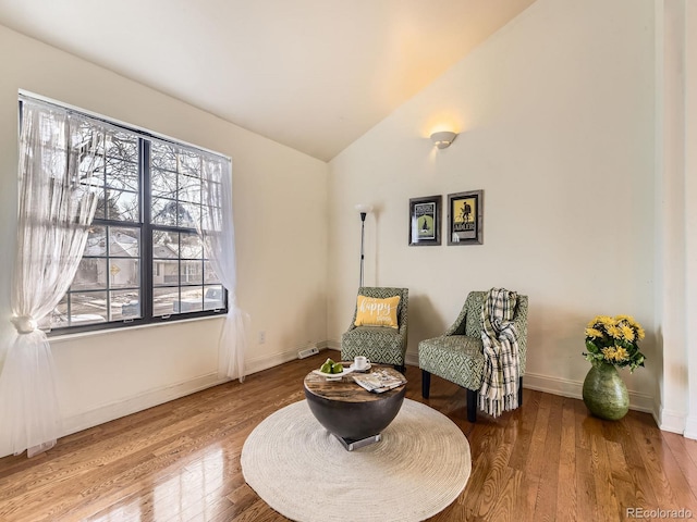 living area featuring hardwood / wood-style flooring and lofted ceiling