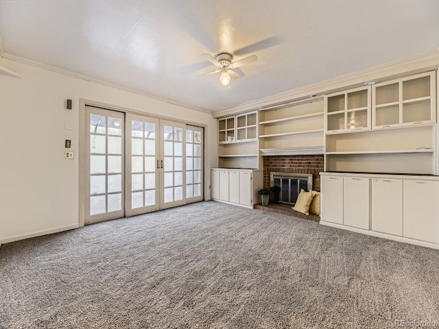 unfurnished living room featuring carpet, french doors, ornamental molding, and a fireplace