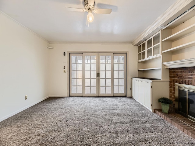 unfurnished living room featuring french doors, carpet flooring, crown molding, and a brick fireplace