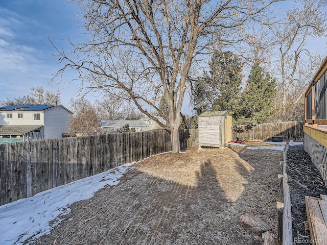 yard covered in snow featuring a storage shed