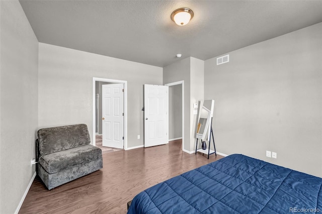 5996 Sun Mesa Cir, Castle Rock, CO 80104 - bedroom with a textured ceiling, visible vents, wood finished floors, and baseboards