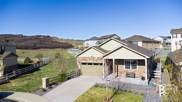 5996 Sun Mesa Cir, Castle Rock, CO 80104 - craftsman house featuring stone siding, concrete driveway, fence, and an attached garage