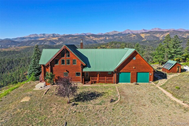 log home with a front yard, a mountain view, a garage, and an outdoor structure