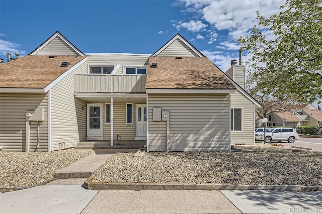 2469 S Xanadu Way Unit A, Aurora, CO 80014 - view of front facade featuring a balcony, covered porch, and a chimney