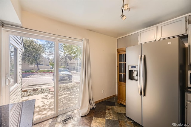 2469 S Xanadu Way Unit A, Aurora, CO 80014 - kitchen featuring fridge with ice dispenser, dark stone finish floors, and baseboards
