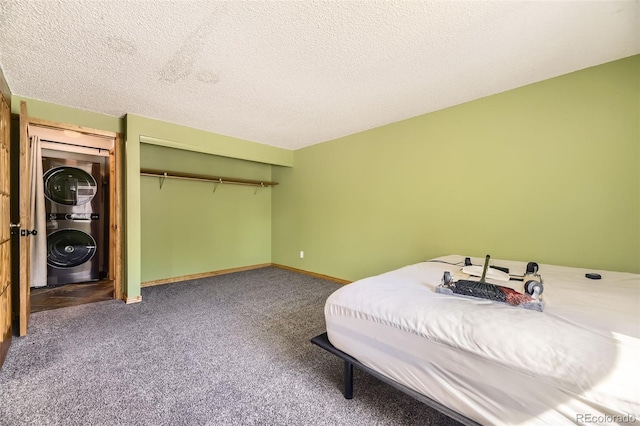 2469 S Xanadu Way Unit A, Aurora, CO 80014 - carpeted bedroom featuring estacked washer and dryer, a closet, a textured ceiling, and baseboards