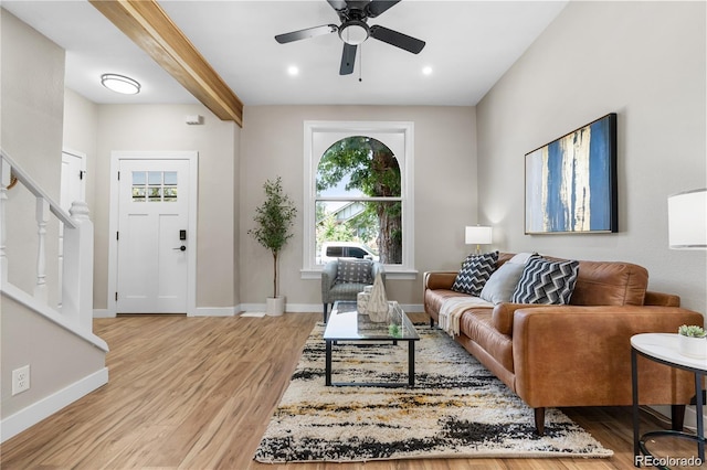 living room featuring beamed ceiling, ceiling fan, and hardwood / wood-style flooring