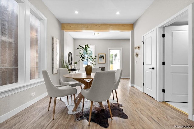 dining space featuring beam ceiling and light hardwood / wood-style flooring