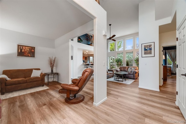 236 E Fair Ln, Centennial, CO 80121 - living room with light wood-style floors, a towering ceiling, ceiling fan, and baseboards