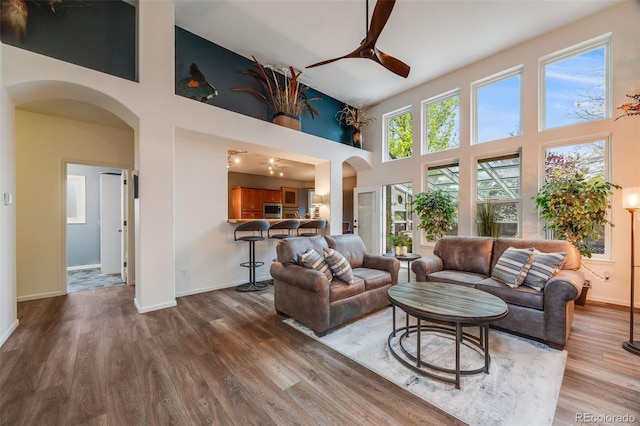 236 E Fair Ln, Centennial, CO 80121 - living area with arched walkways, high vaulted ceiling, ceiling fan, wood finished floors, and baseboards