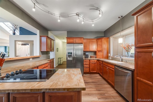 236 E Fair Ln, Centennial, CO 80121 - kitchen featuring appliances with stainless steel finishes, a sink, butcher block counters, light wood-style floors, and brown cabinets