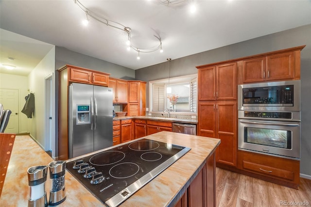 236 E Fair Ln, Centennial, CO 80121 - kitchen with appliances with stainless steel finishes, light wood finished floors, brown cabinetry, and butcher block counters