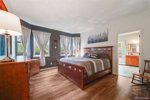236 E Fair Ln, Centennial, CO 80121 - bedroom with light wood-type flooring, multiple windows, baseboards, and ensuite bath