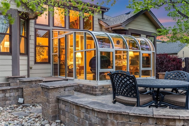 236 E Fair Ln, Centennial, CO 80121 - back of house at dusk with outdoor dining space and a sunroom