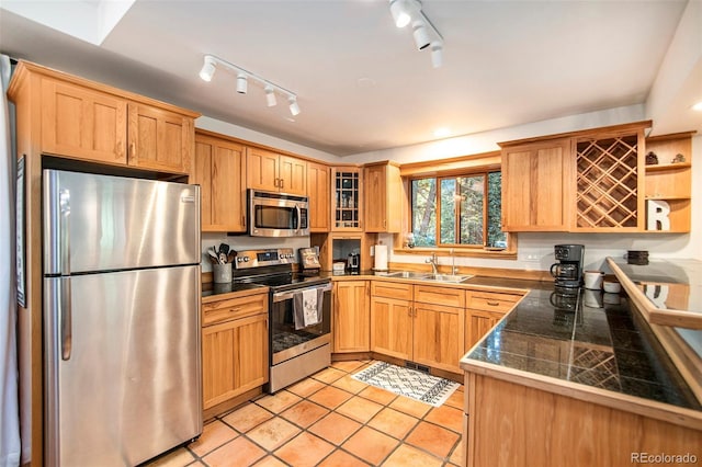 28192 Shadow Mountain Dr, Conifer, CO 80433 - kitchen with stainless steel appliances, a sink, tile countertops, track lighting, and glass insert cabinets