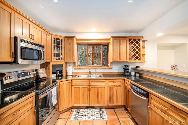 28192 Shadow Mountain Dr, Conifer, CO 80433 - kitchen featuring stainless steel appliances, a sink, glass insert cabinets, light tile patterned floors, and recessed lighting