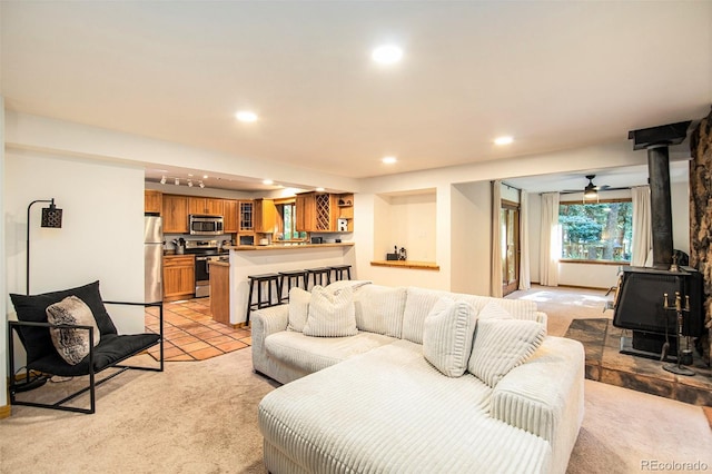 carpeted living room with a wood stove