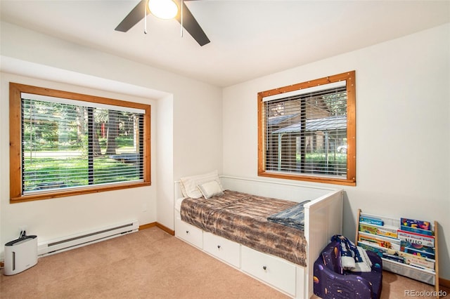 bedroom featuring ceiling fan, light colored carpet, a baseboard radiator, and multiple windows