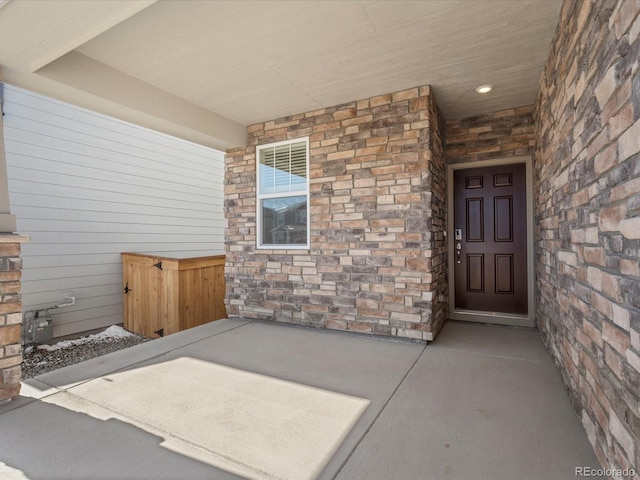 entrance to property with stone siding and covered porch