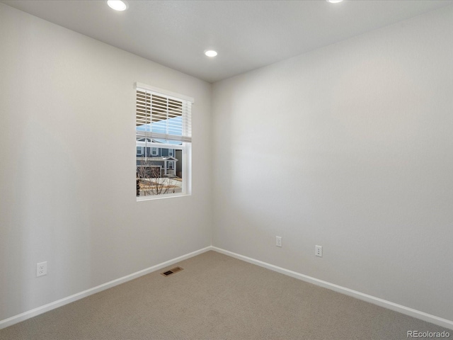 spare room featuring recessed lighting, carpet, visible vents, and baseboards