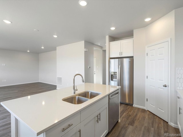 kitchen with a sink, dark wood finished floors, stainless steel appliances, white cabinets, and light countertops