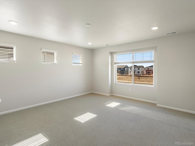 unfurnished room with visible vents, recessed lighting, baseboards, and carpet floors